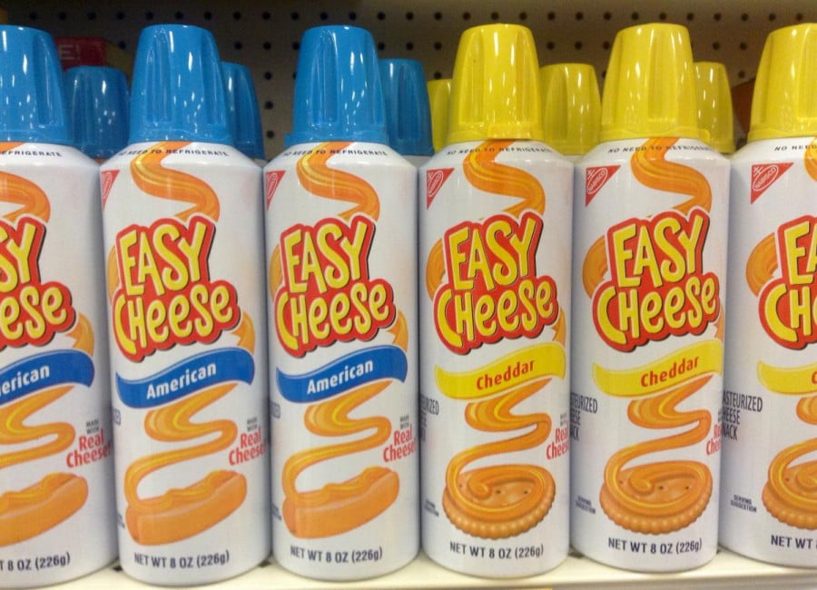 Cans of 'Easy Cheese' on a shelf in a store