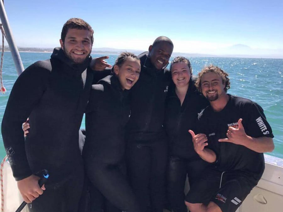 People in wetsuits on a boat on the ocean