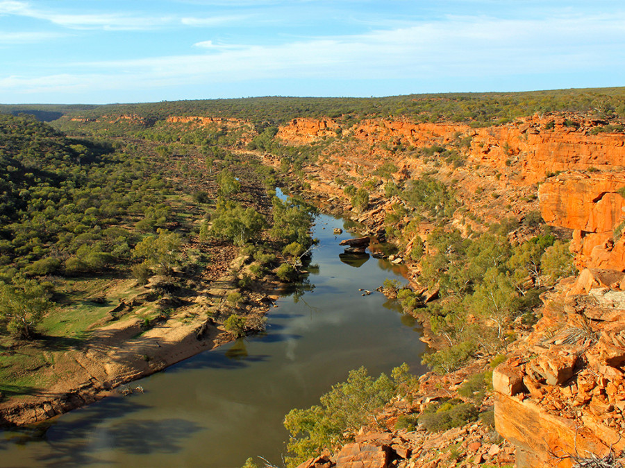 A river and red cliffs and trees in Queensland, Northern Territory, Australia