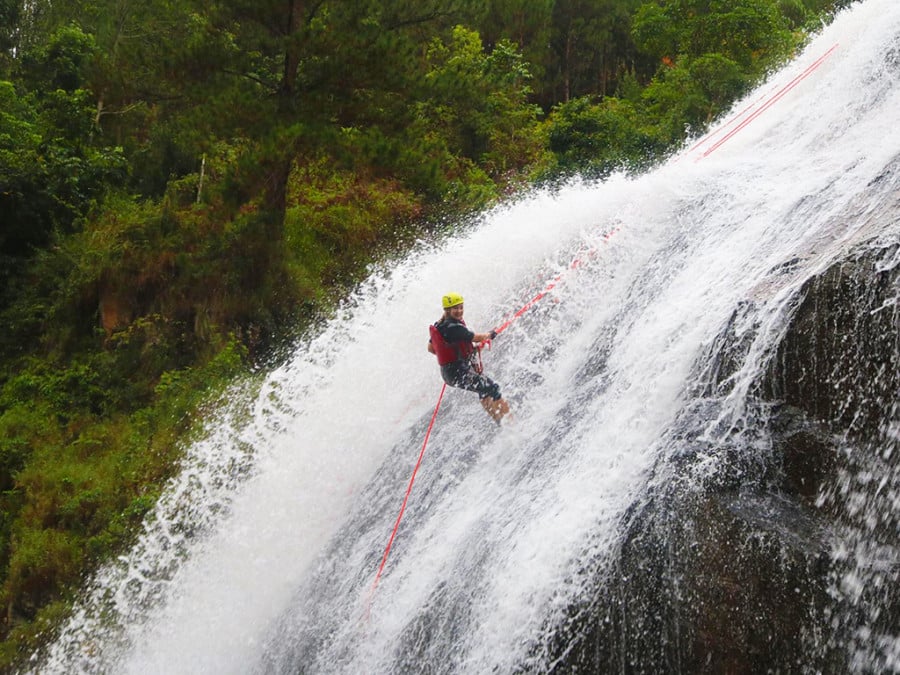 A person rapelling down a waterfall