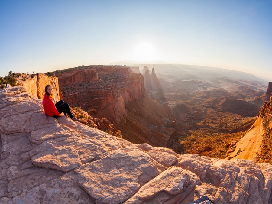 A person sitting on the edge of a cliff overlooking the Grand Canyon