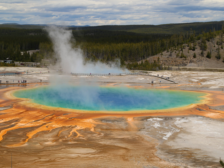 A multi-coloured hot spring with rising steam